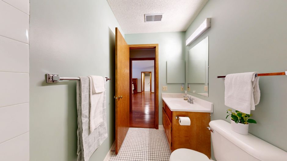 Bright bathroom featuring wooden cabinets and white towels for a clean, modern look.
