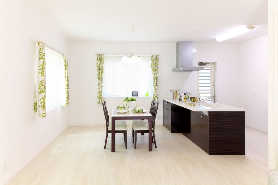 Sleek modern kitchen and dining area with natural light and minimalistic decor.